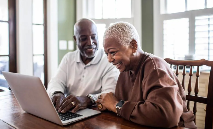 Older couple looking at life insurance policies on computer